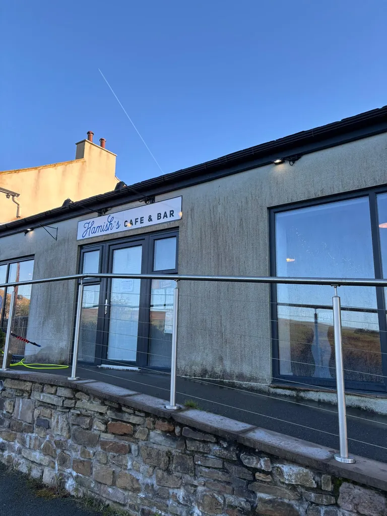 Café frontage with green algae streaks on the render before cleaning