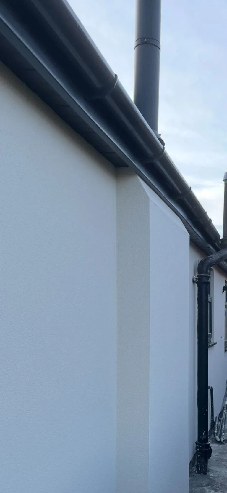 Smooth white rendering guttering detail finish